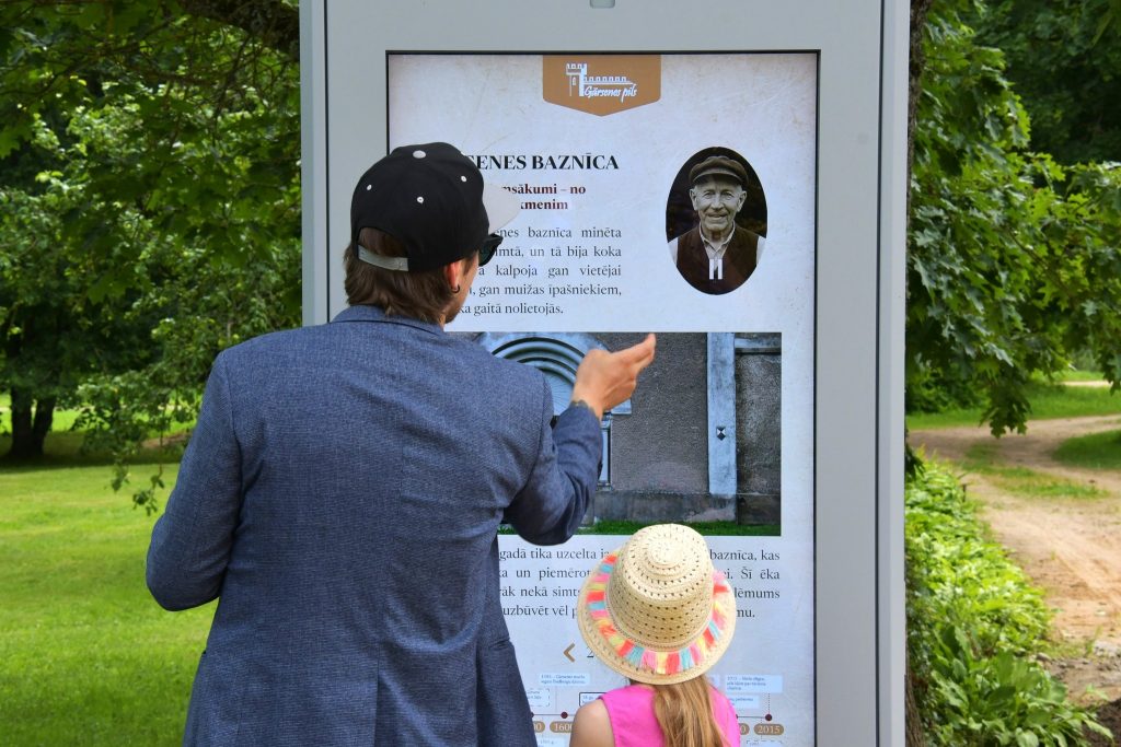 Tūrists izmanto Gārsenes gidu pie muižas ieejas