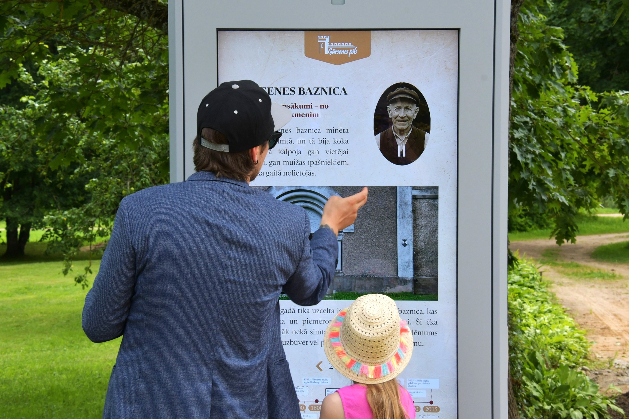 Tūrists izmanto Gārsenes gidu pie muižas ieejas